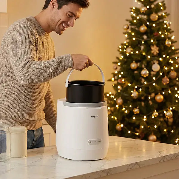 A person lifting the removable inner bucket from the Moreborn composter with a convenient handle.