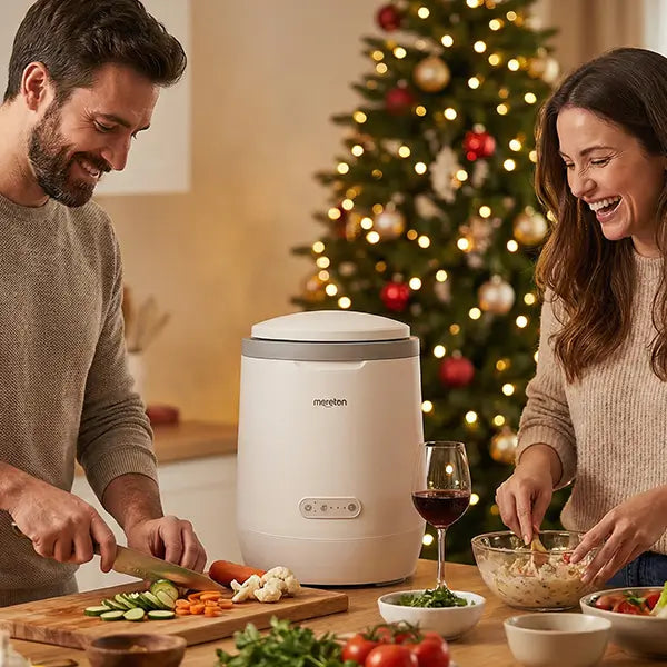 A happy couple preparing dinner in a cozy kitchen with a Moreborn smart food waste composter during Christmas.